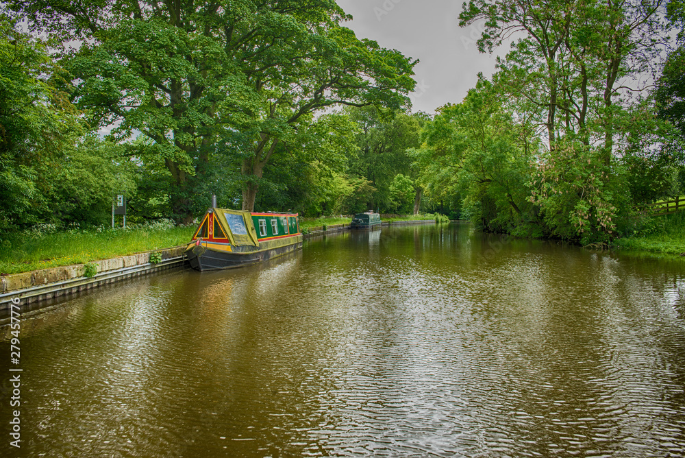 Narrowboats on a British canal in rural setting