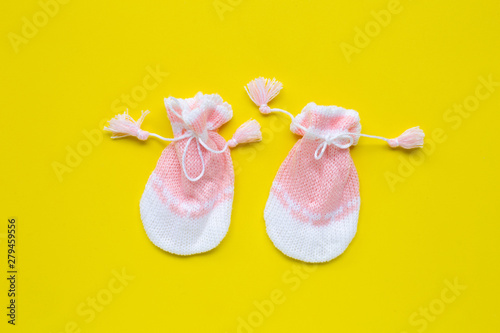 Fototapeta Naklejka Na Ścianę i Meble -  Baby gloves on yellow background.