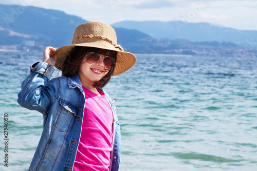 girl in hat and sunglasses walking on the beach, concept of summer holidays and relaxation © tetxu