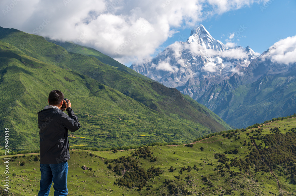 A photographer takes pictures for the Siguniang mountains in Sichuan, China.