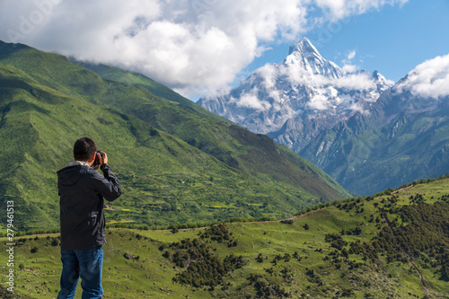 A photographer takes pictures for the Siguniang mountains in Sichuan, China.