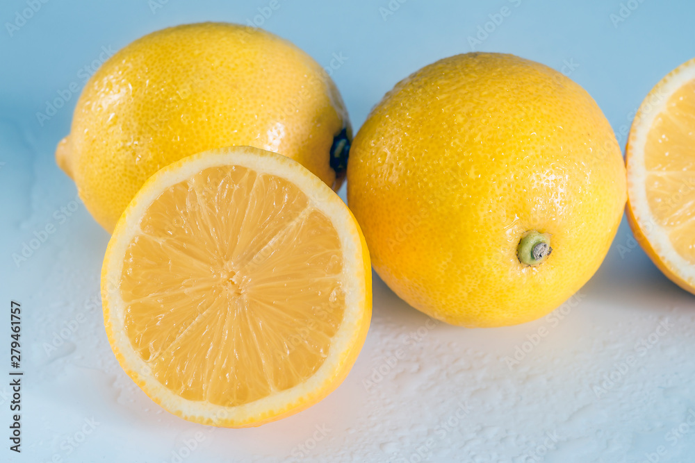 Mature juicy lemons on a blue and white background with lemon juice. Vitamins and fruits