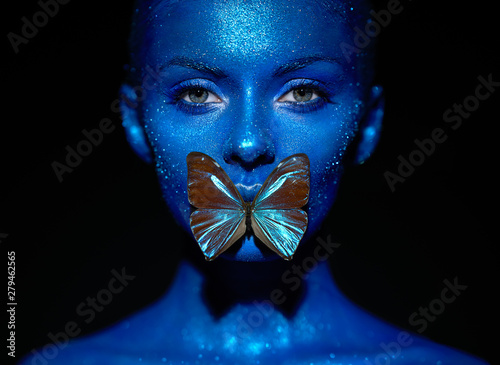 Fotografie Fashion model woman in blue bright sparkles and neon lights posing in studio