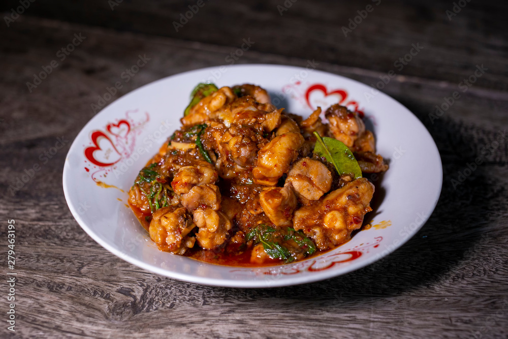 Stir-fried chicken with red curry paste. Thai local food recipe on wood table.