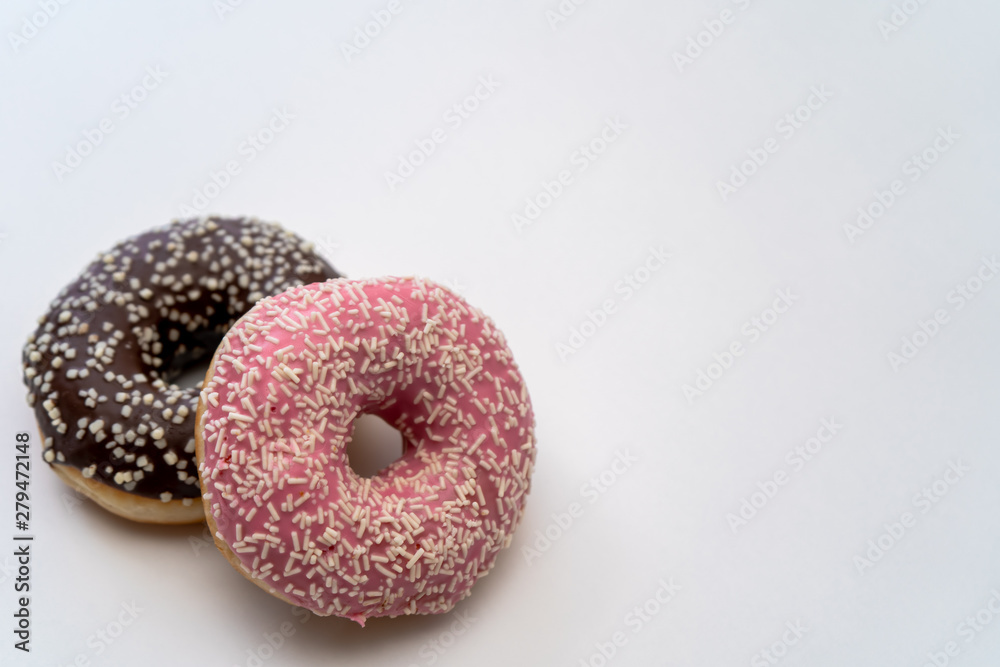 Close-up of tasty chocolate and pink fruit donut isolated on the left on white background Close-up of tasty chocolate and pink fruit donut isolated on the left on white background