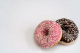 Close-up of tasty chocolate and pink fruit donut isolated on the right on white background
