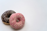 Close-up of tasty chocolate and pink fruit donut isolated on the left on white background