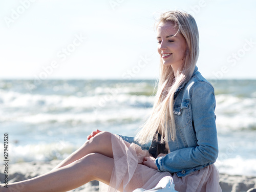Young cheerful girl on the seashore. Young blonde woman smiling. Young cheerful woman on a walk © Ulia Koltyrina