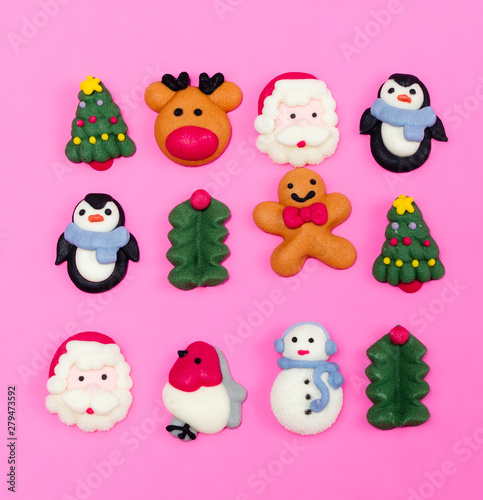 Sugar glaze figurines for Christmas decoration. Christmas food decorations.  Christmas symbols. Christmas cookies on pink background from above. Desert.