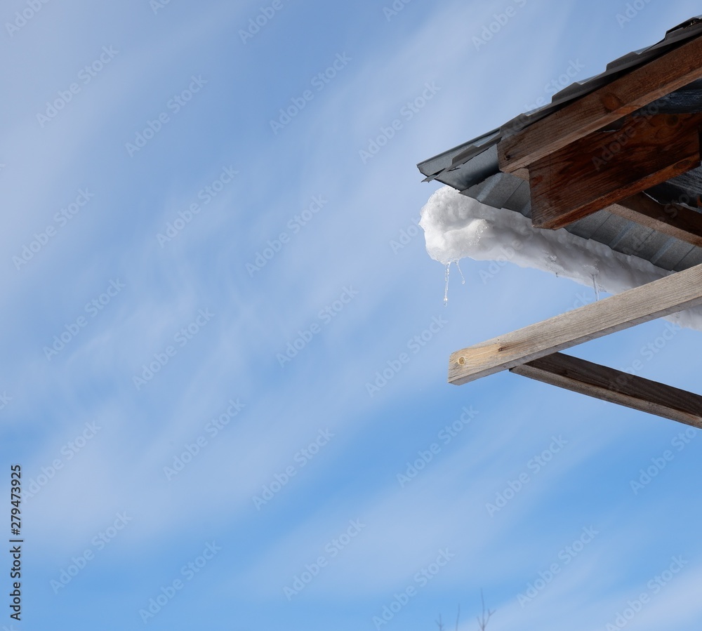 metal roof angle with snow against blue sky with clouds metal roof angle with snow against blue sky with clouds