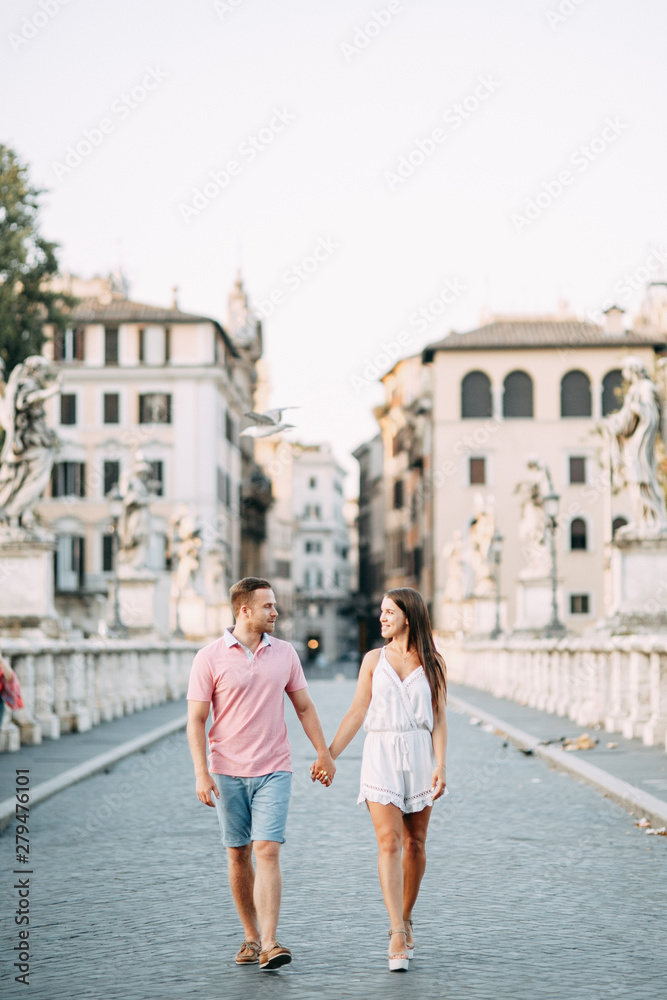 Happy couple at dawn strolling in Italy. Morning summer photo shoot in Rome.