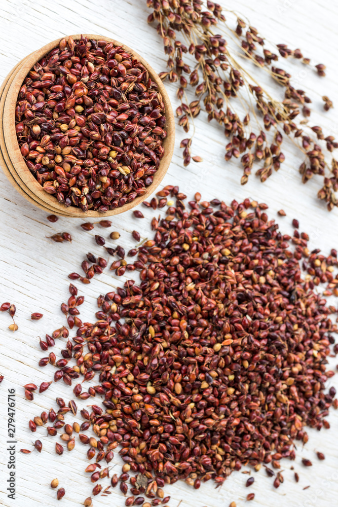 Box with red millet and millet grain on a white background Box with red millet and millet grain on a white background