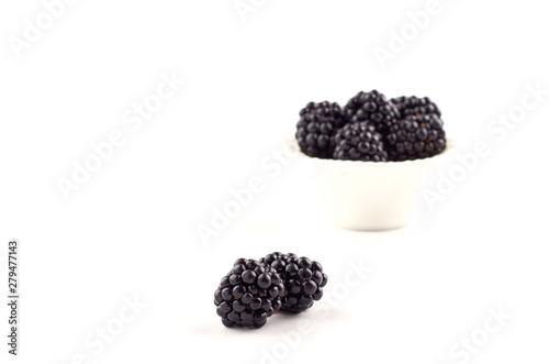 Blackberries berries on a saucer isolated on a white background.