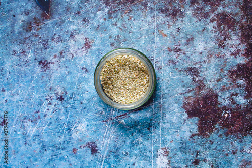 Ubtan. Herbs wash for face skin.In a glass jar on a blue background.