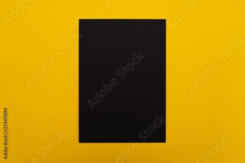 Blank black paper sheet on orange background. Layout for business, posters and banners.