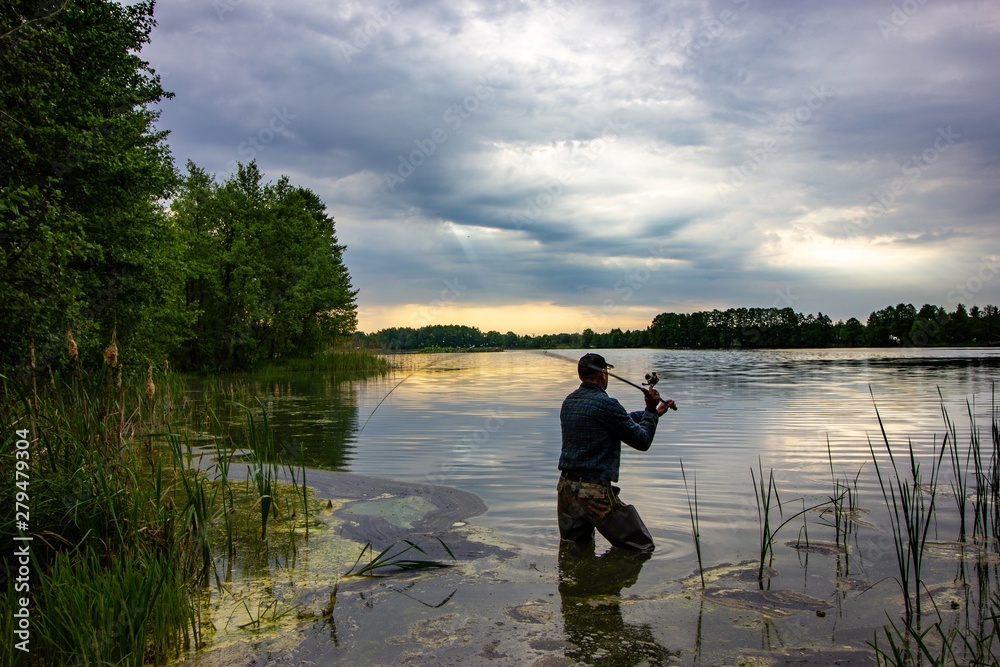 angler catching the fish during overcast day