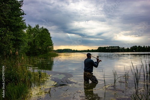 angler catching the fish during overcast day