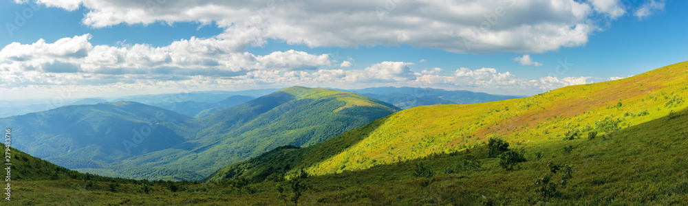 beautiful panorama of a summer landscape. grassy hills and distant ridges, amazing scenery in mountains. sunny weather with cloudy sky on a windy day. picturesque view in to the horizon