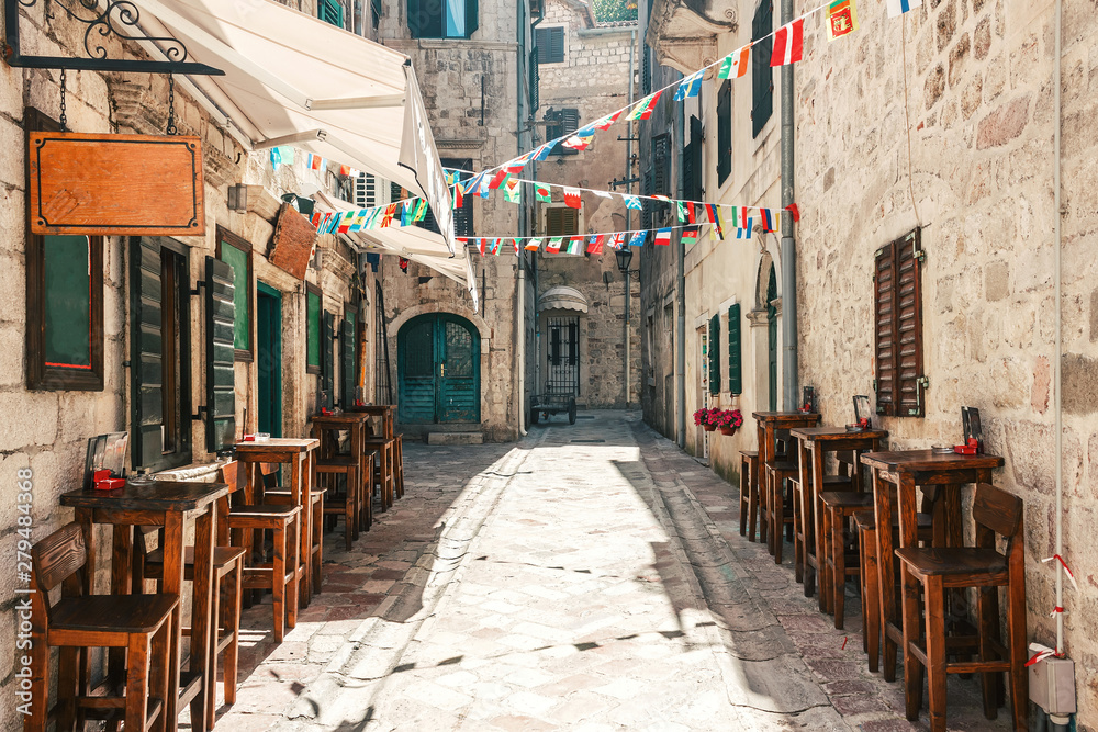 Old historical buildings with street cafe in the central district of ancient city Kotor in Montenegro