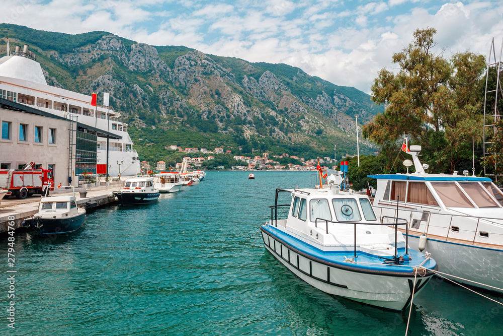 Boats in the water at harbor in the ancient town Kotor surrounded by mountains, Montenegro