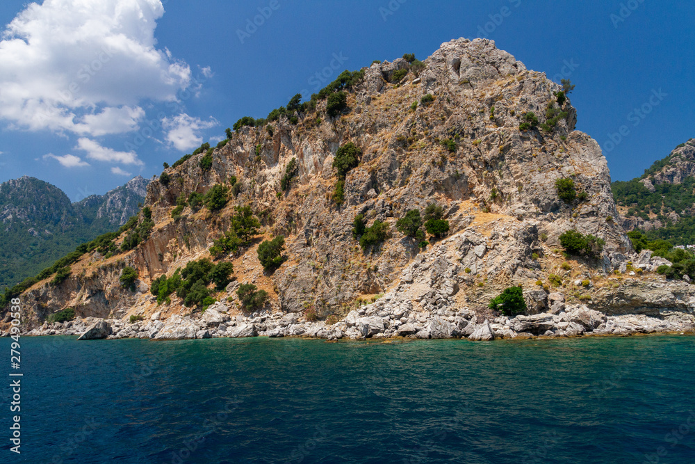 Scenic view of the Aegean Islands. The unique shades of the sea and the rocks covered with pine trees.