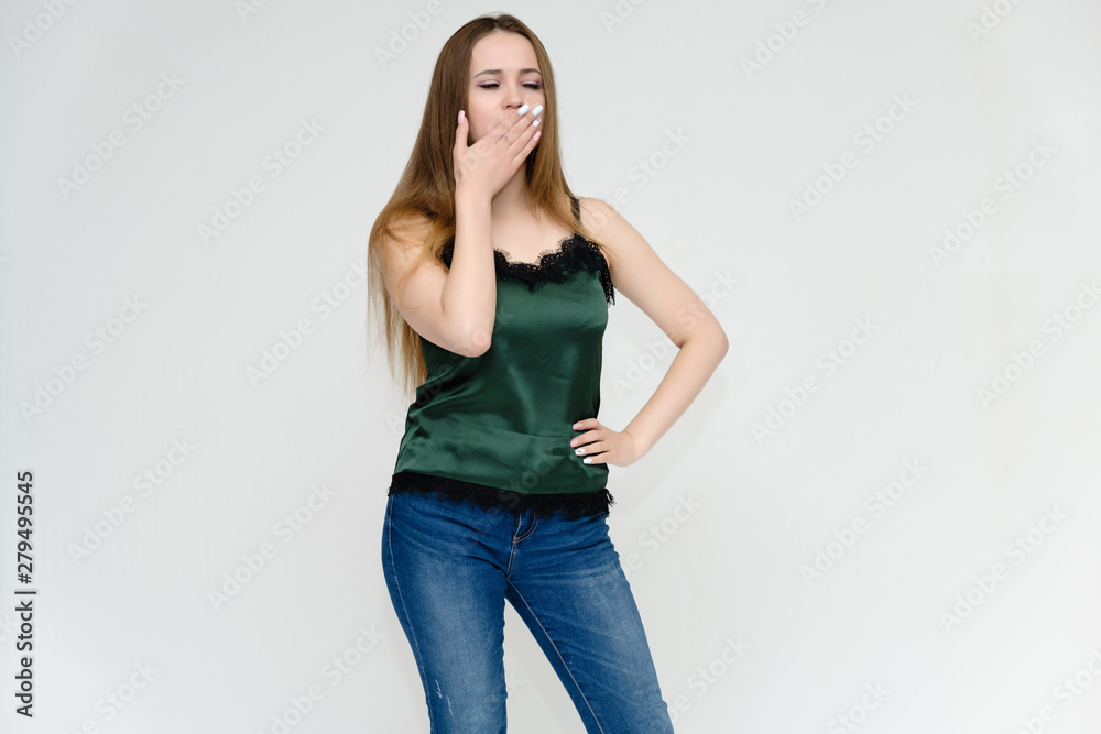 Concept portrait above the knee of a pretty girl, a young woman with long beautiful brown hair and a green t-shirt and blue jeans on a white background. In studio in different poses showing emotions. Concept portrait above the knee of a pretty girl, a young woman with long beautiful brown hair and a green t-shirt and blue jeans on a white background. In studio in different poses showing emotions.