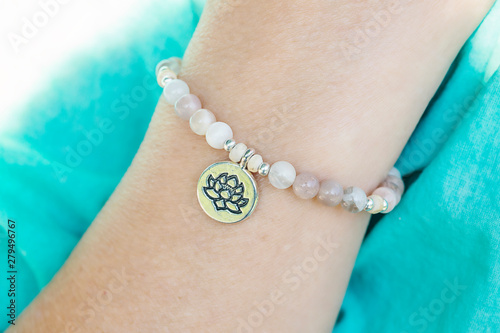 Mineral sun stone beads bracelet with lotus pendant on female wrist