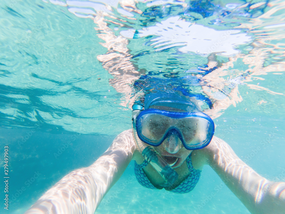 Fototapeta premium woman taking a selfie snorkeling in clear tropical waters - active holiday