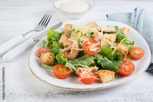 Traditional Italian Caesar salad with chicken, tomatoes and Parmesan