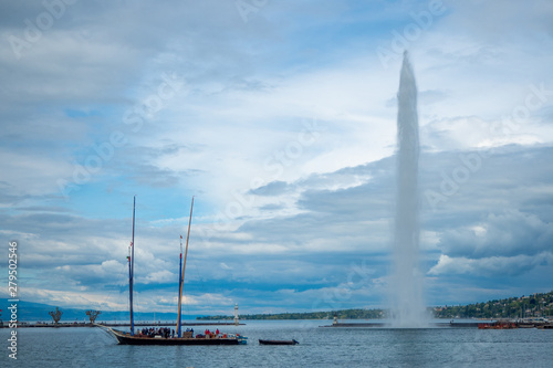 Beautiful panorama view of Geneva lake and Jet d'eau fountain with boat on cloudy sky background with copy space, Switzerland