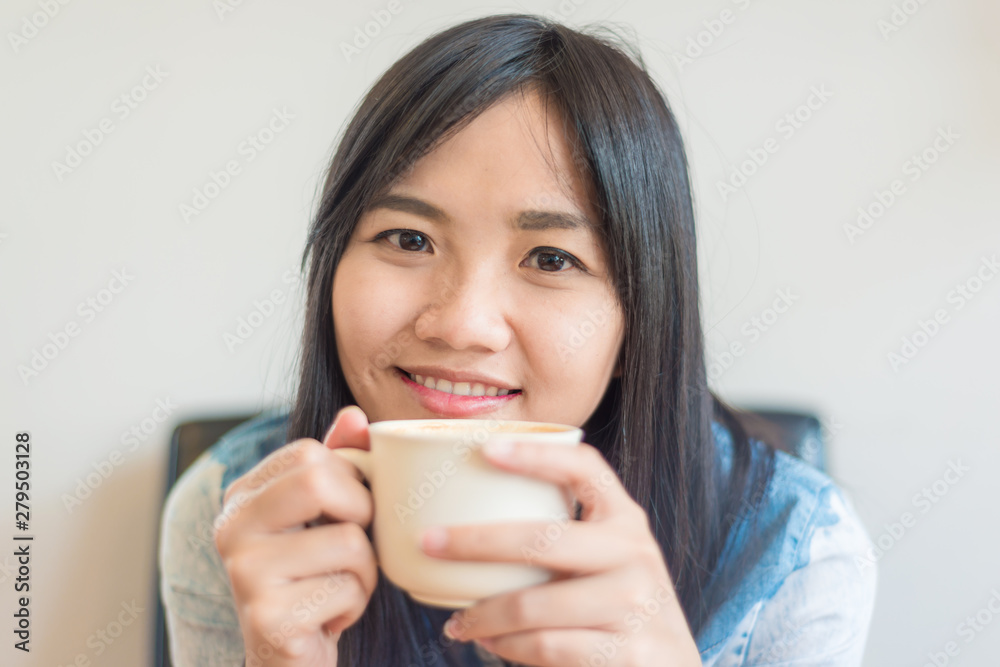 Beautiful asian women hold hot coffee cup in cafe Beautiful asian women hold hot coffee cup in cafe