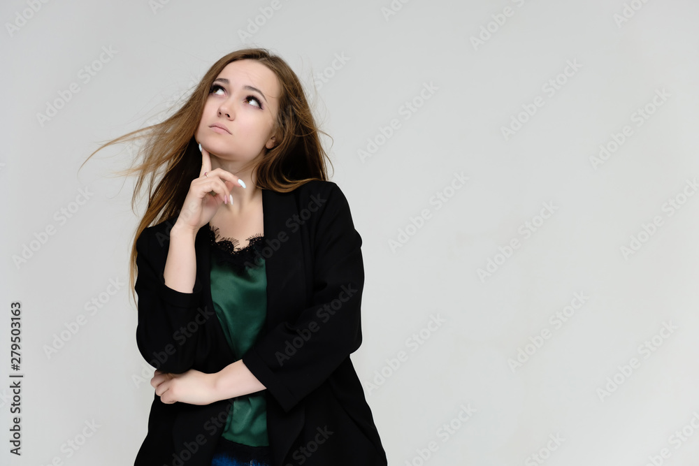 Concept portrait for the waist of a pretty girl, a young woman with long beautiful brown hair and a black jacket and blue jeans on a white background. In studio in different poses showing emotions. Concept portrait for the waist of a pretty girl, a young woman with long beautiful brown hair and a black jacket and blue jeans on a white background. In studio in different poses showing emotions.