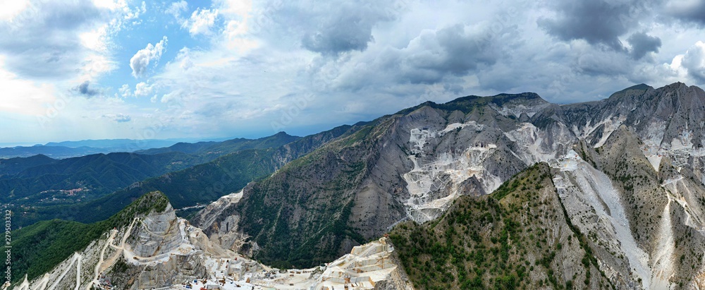 Obraz premium Aerial view of mountain of stone and marble quarries in the regional natural park of the Apuan Alps located in the Apennines in Tuscany, Massa Carrara Italy. Open pit mine