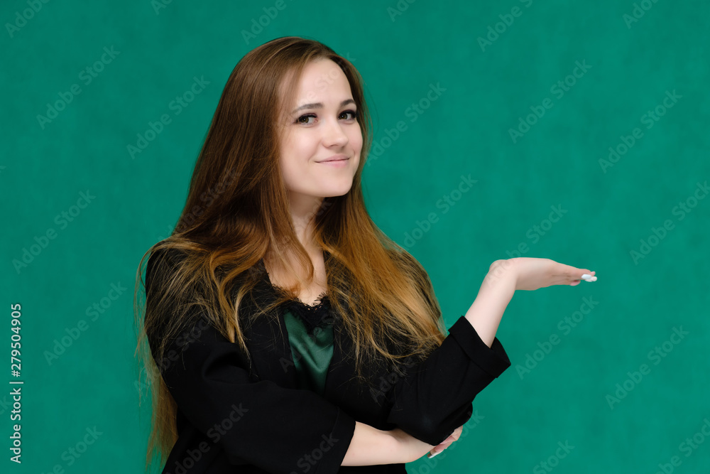 Concept close-up portrait of a pretty girl, a young woman with long beautiful brown hair and in a black jacket on a green background. In the studio in different poses showing emotions. Concept close-up portrait of a pretty girl, a young woman with long beautiful brown hair and in a black jacket on a green background. In the studio in different poses showing emotions.