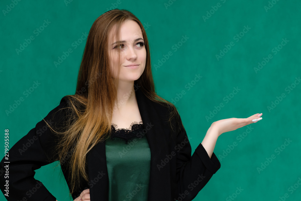 Concept close-up portrait of a pretty girl, a young woman with long beautiful brown hair and in a black jacket on a green background. In the studio in different poses showing emotions. Concept close-up portrait of a pretty girl, a young woman with long beautiful brown hair and in a black jacket on a green background. In the studio in different poses showing emotions.