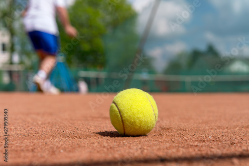 yellow tennis ball on clay court during training session at tennis academy © Bonsales