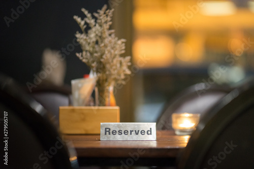Table in vintage or bistro restaurant is already reserved for customer. Objects on table are prepared.  photo