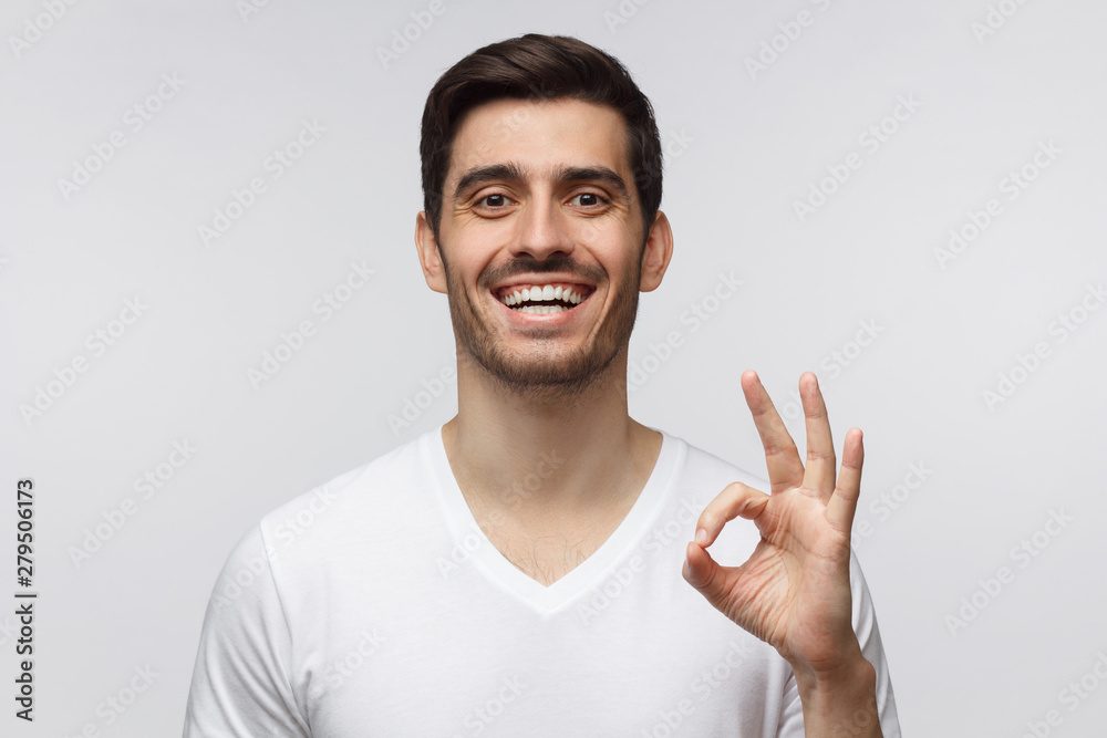 Young laughing man showing OK sign. Caucasian male shows okay gesture with fingers Young laughing man showing OK sign. Caucasian male shows okay gesture with fingers