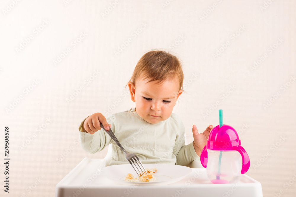 Baby toddler eating pancakes with fork. Isolated. Copy space Baby toddler eating pancakes with fork. Isolated. Copy space