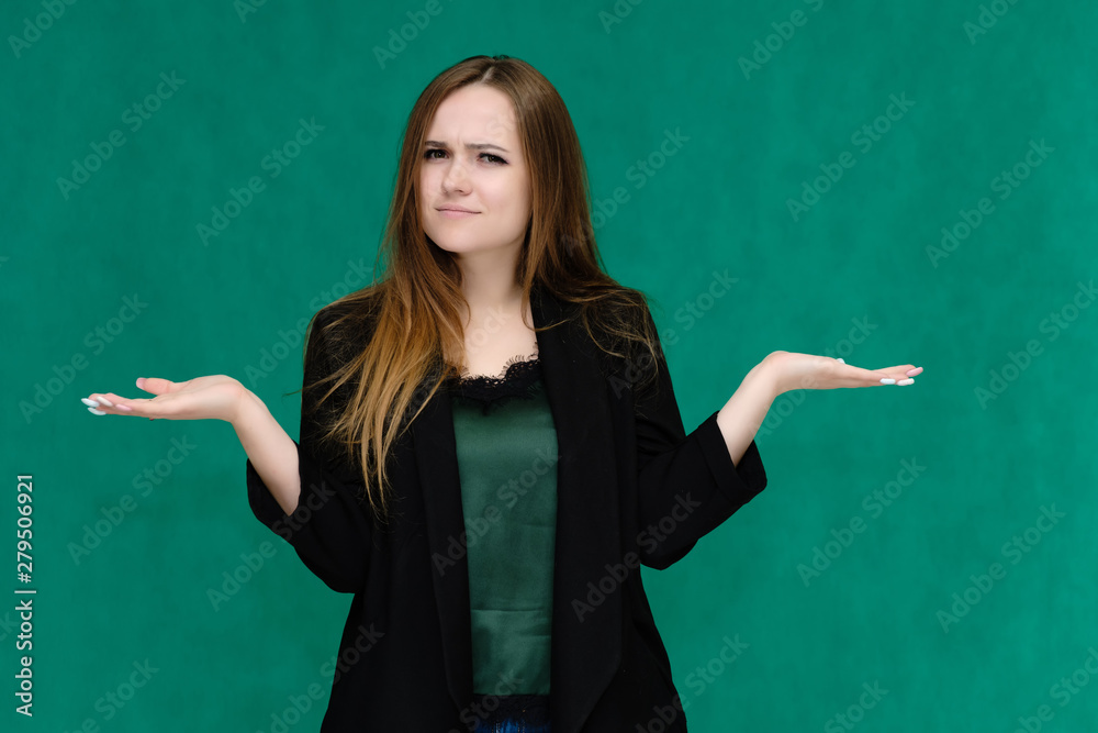 Concept portrait for a belt of a pretty girl, young woman with beautiful brown hair and in a black jacket and green T-shirt on a green background. In the studio in different poses showing emotions. Concept portrait for a belt of a pretty girl, young woman with beautiful brown hair and in a black jacket and green T-shirt on a green background. In the studio in different poses showing emotions.