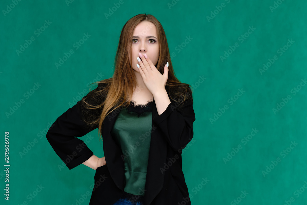 Concept portrait for a belt of a pretty girl, young woman with beautiful brown hair and in a black jacket and green T-shirt on a green background. In the studio in different poses showing emotions. Concept portrait for a belt of a pretty girl, young woman with beautiful brown hair and in a black jacket and green T-shirt on a green background. In the studio in different poses showing emotions.