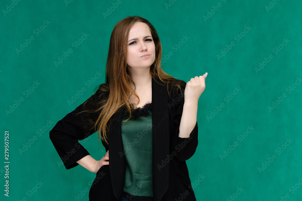 Concept portrait for a belt of a pretty girl, young woman with beautiful brown hair and in a black jacket and green T-shirt on a green background. In the studio in different poses showing emotions. Concept portrait for a belt of a pretty girl, young woman with beautiful brown hair and in a black jacket and green T-shirt on a green background. In the studio in different poses showing emotions.