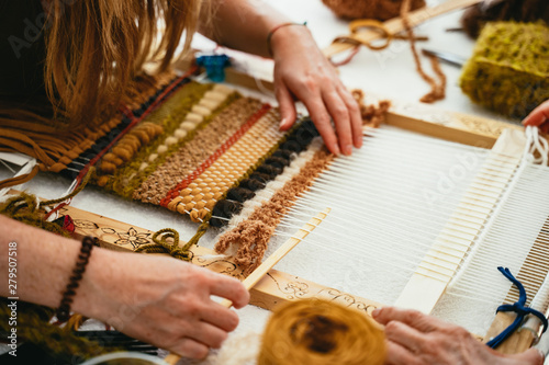 Woman trying her hand at weaving a tapestry