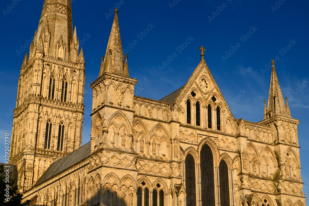 Great West Front facade of Salisbury Cathedral with statuary of Saints and Angels and Spire in gold evening light in Salisbury England