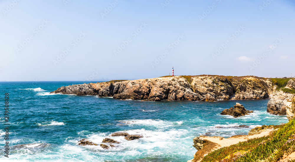 View of the cliffs and the lighthouse near praia pequena beach in Porto Covo, Portugal