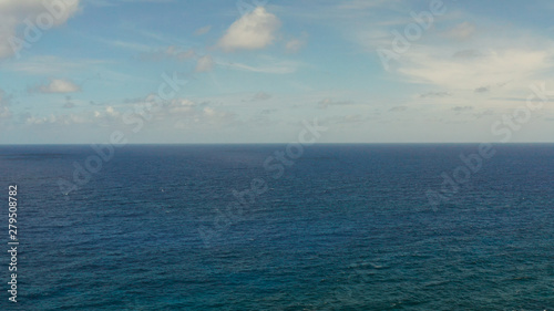 Surface of blue ocean with waves and blue sky with cloud  aerial view. Water cloud horizon background. Blue sea water with waves against sky.