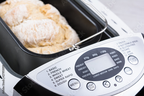 Homemade white flour bread baked in bread maker with digital display
