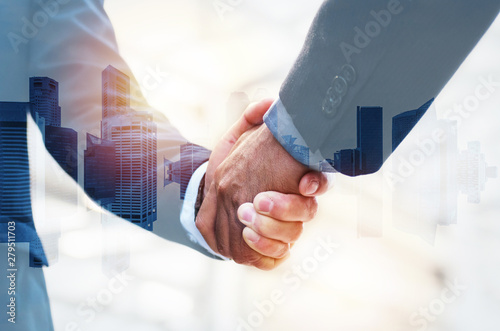 Welcome. double exposure image of investor business man shaking hands with partner for successful meeting deal with during sunrise and cityscape background, investment, partnership, teamwork concept