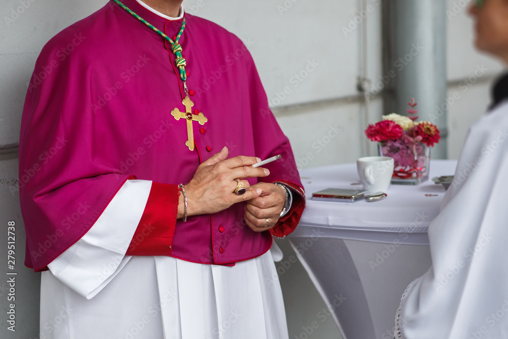Obraz premium a priest in a purple mantle with a cigarette in his hand