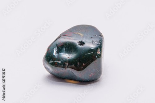Indian Achat deep green gemstone with red and yellow structures all over it isolated photo